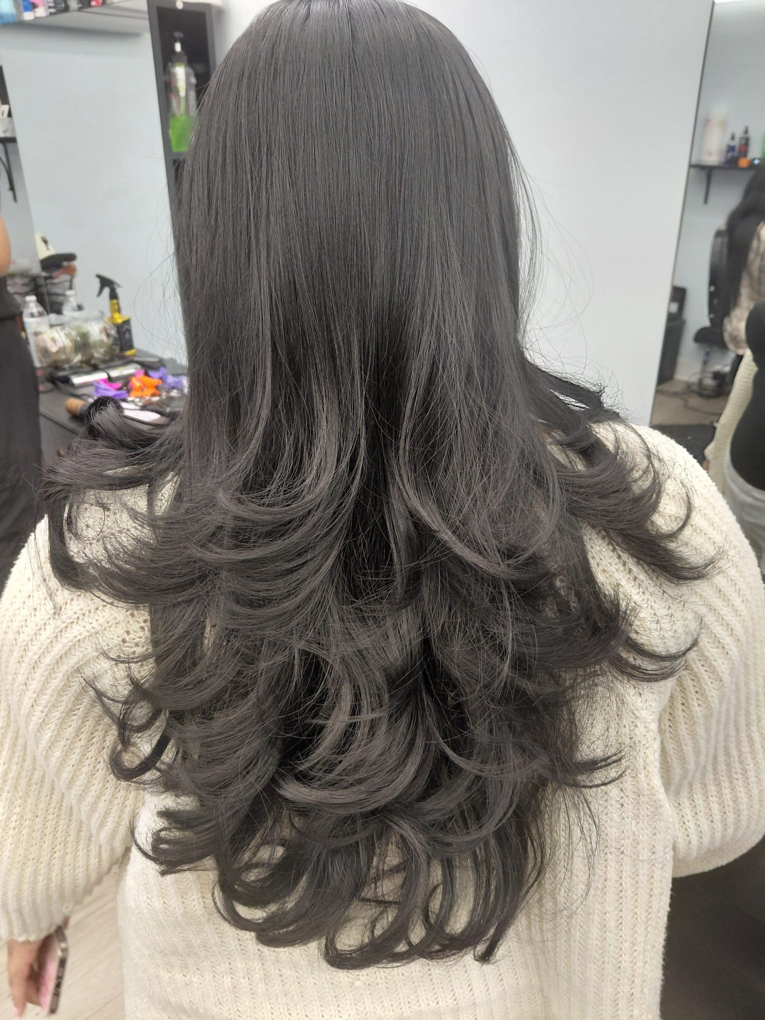 Long dark layered hair seen from behind in our salon